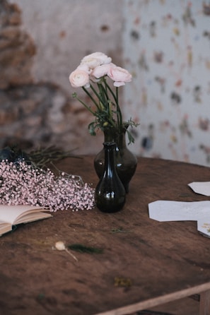 A rustic wooden table displaying the two growing volumes alongside fresh wildflowers.