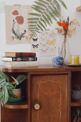 A rattan side cabinet with natural textures, styled with plants and books on top.