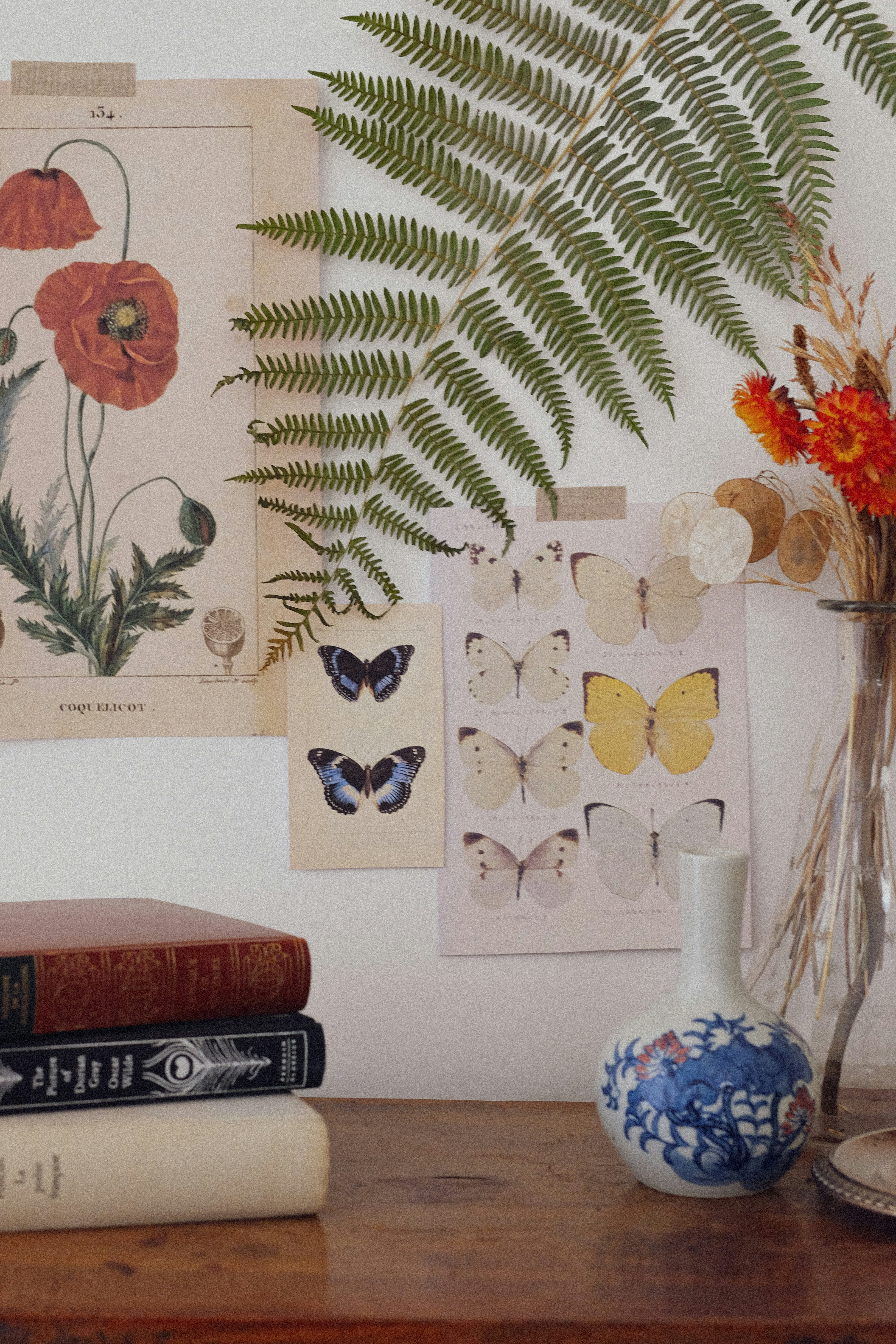 a wooden table topped with books and a vase filled with flowers