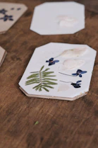Elegant epoxy resin coasters with natural flower inclusions arranged on a cozy coffee table.