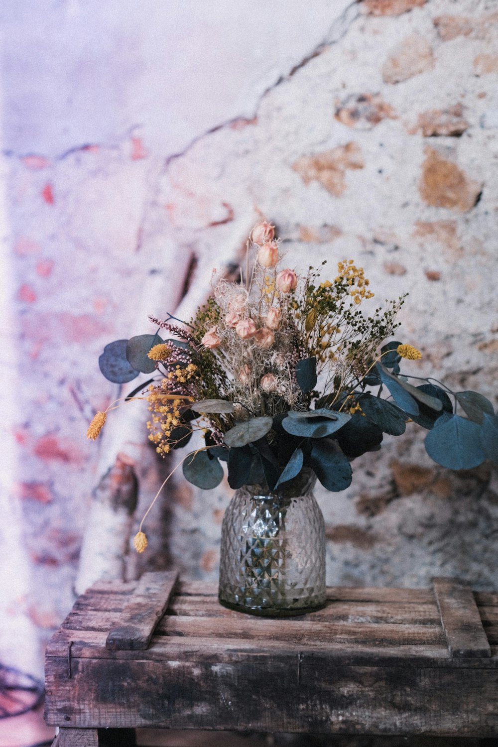 a vase filled with flowers sitting on top of a wooden table