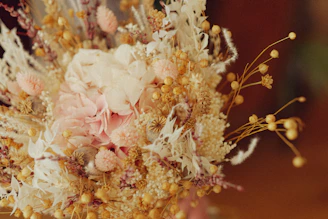 A beautifully arranged wedding bouquet combining dried and fresh flowers in soft pastel tones.