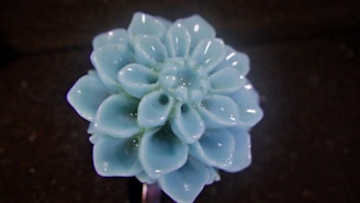 Close-up of delicate handmade ceramic flowers with soft pastel colors on a wooden table.