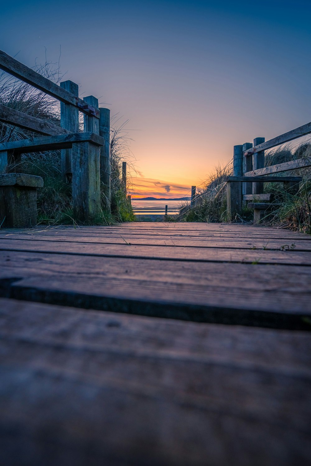 a wooden deck with a sunset in the background