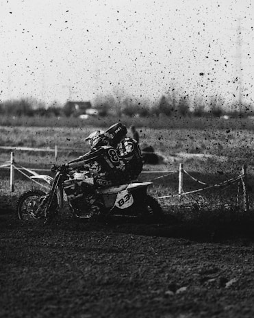 A dynamic shot capturing the intense focus of a rider navigating a sharp turn with mud splashing.
