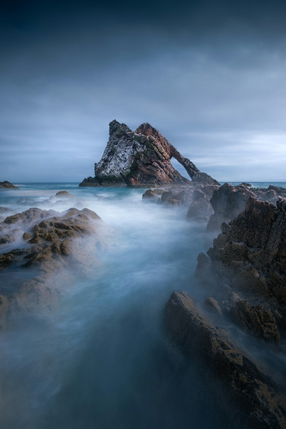 a large rock in the middle of a body of water