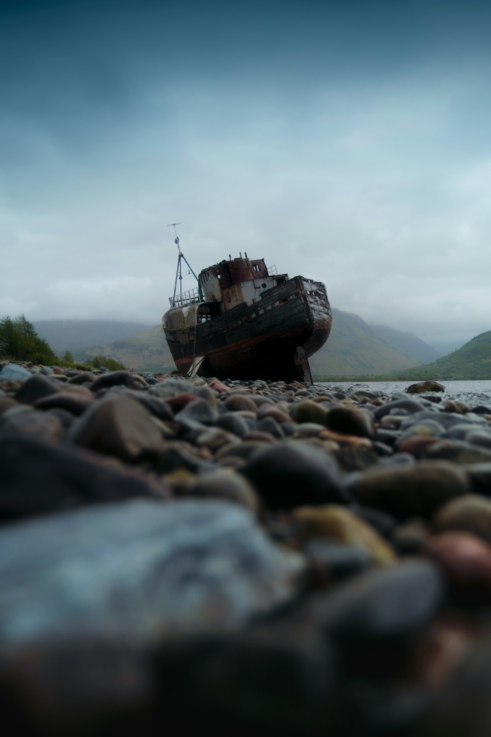 a boat sitting on top of a rocky beach