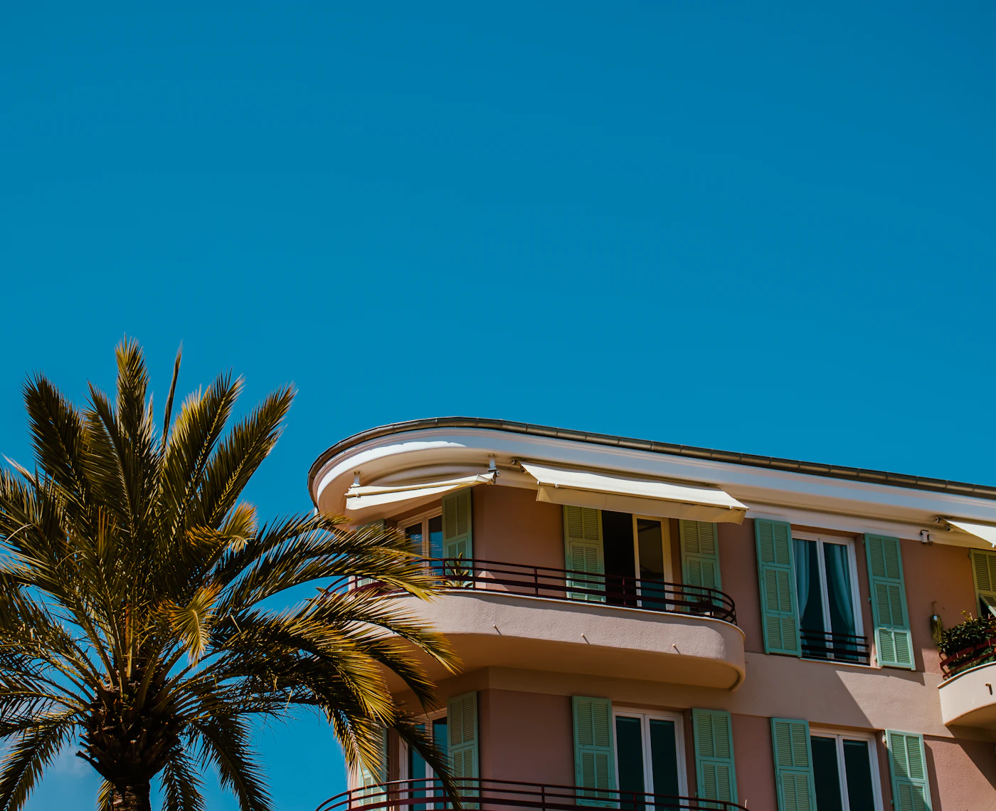 Résidence moderne aux façades blanches avec palmiers et balcons