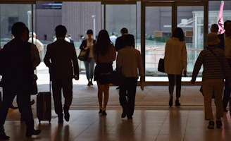 a group of people walking through a lobby