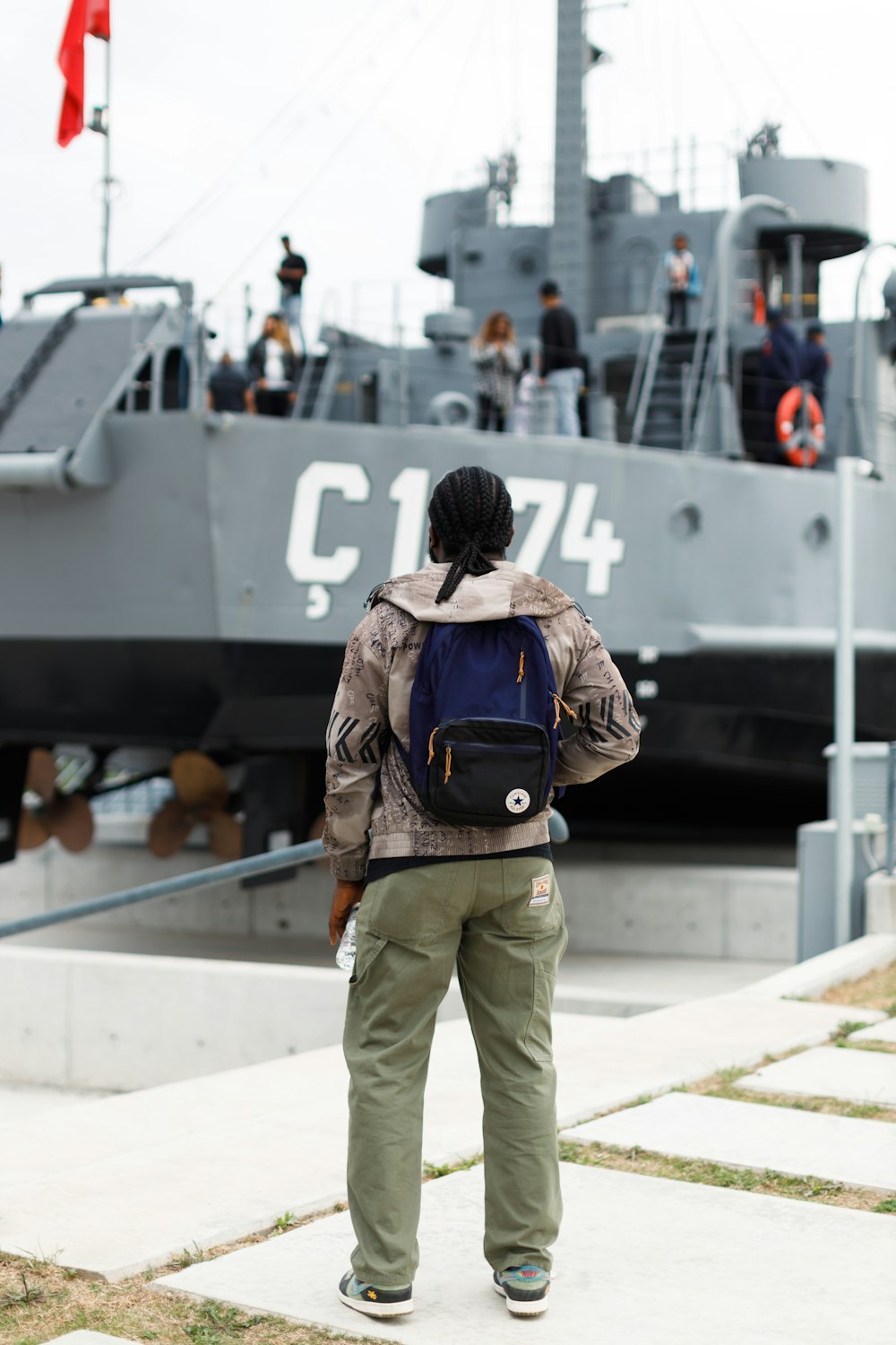 a person with a backpack standing in front of a boat