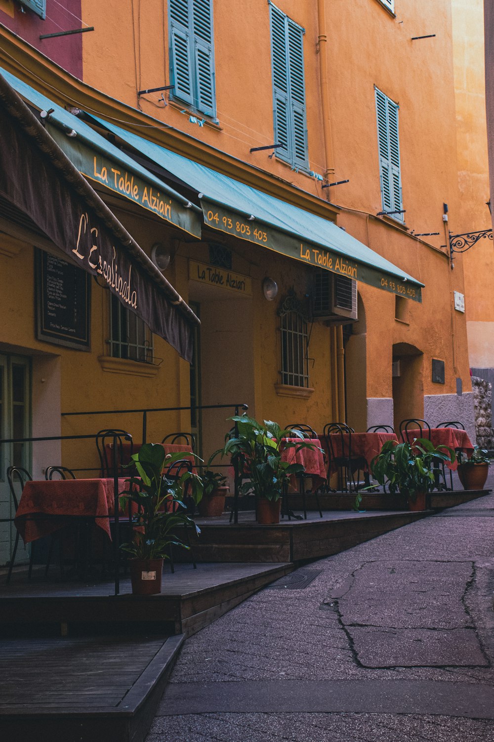 a narrow street lined with tables and chairs