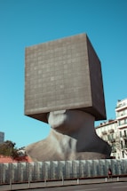 a large sculpture of a person's head in front of a building