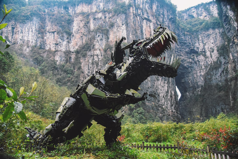 a large dinosaur statue in the middle of a mountain