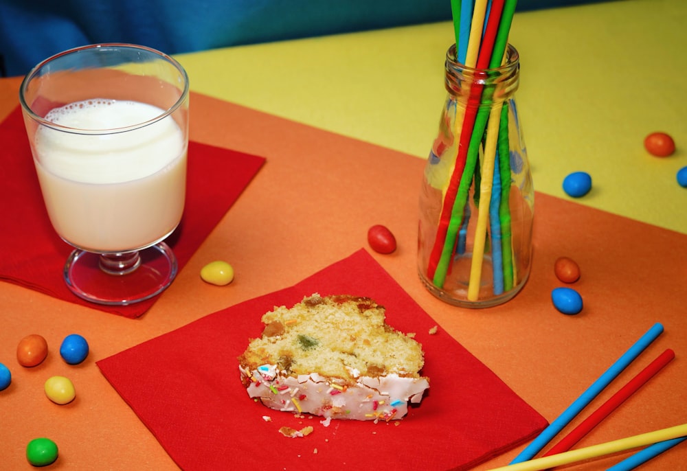 a cup of milk and a cookie on a table