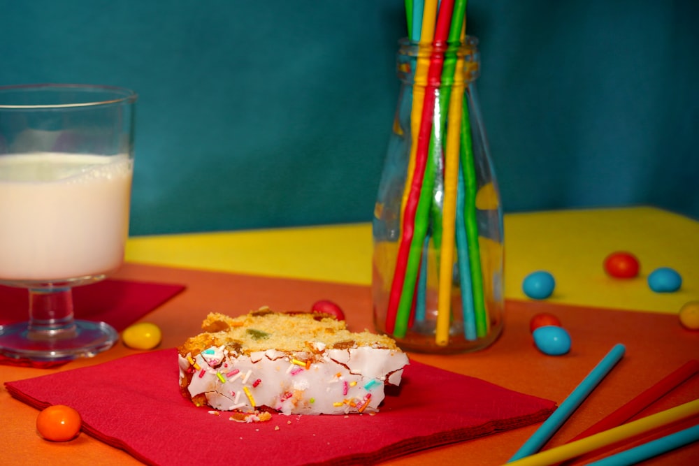 a table topped with a piece of cake next to a glass of milk