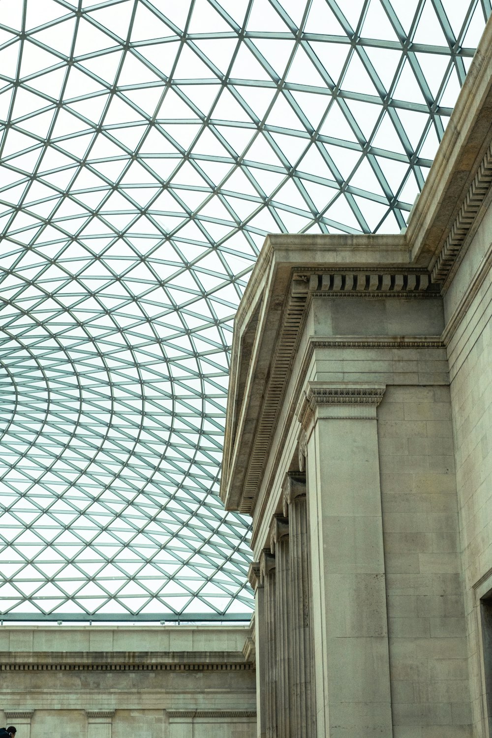 a man standing under a glass roof in a building