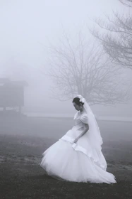 A wide-angle shot of a bride walking along a misty Niagara riverside at dawn.