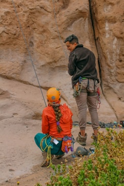 a man standing next to a woman on top of a cliff