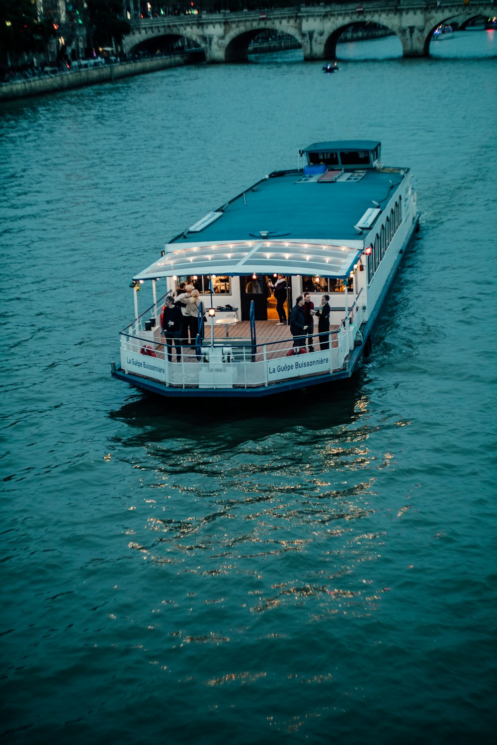 a boat is traveling down the water near a bridge