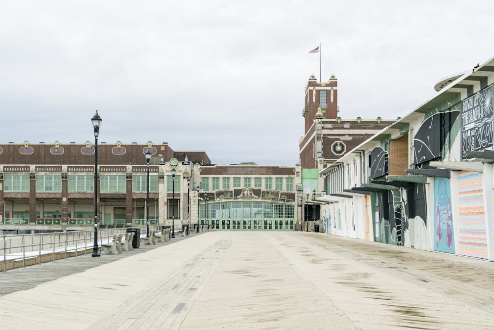 an empty street in front of a building with a clock tower in the background