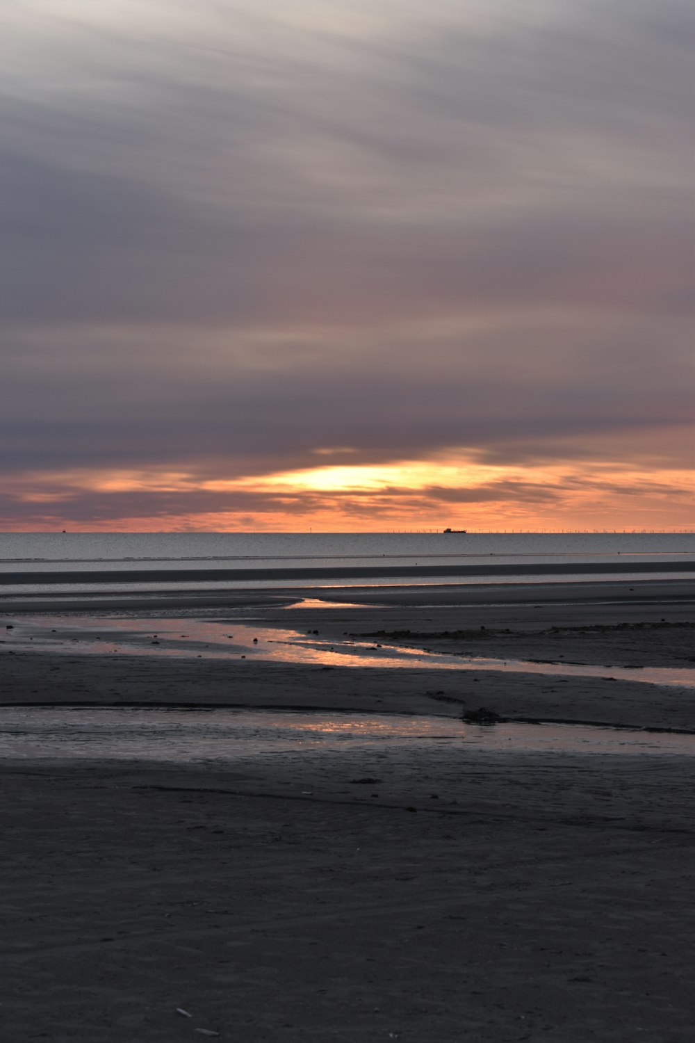 a person riding a horse on a beach at sunset