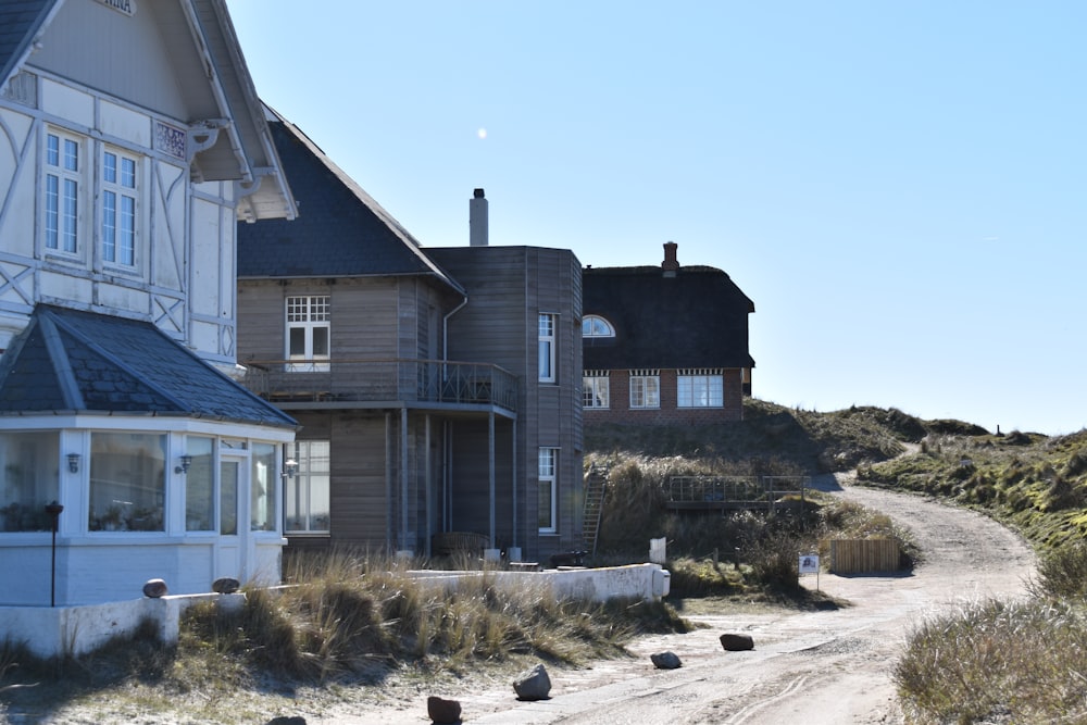 a couple of houses sitting on the side of a dirt road