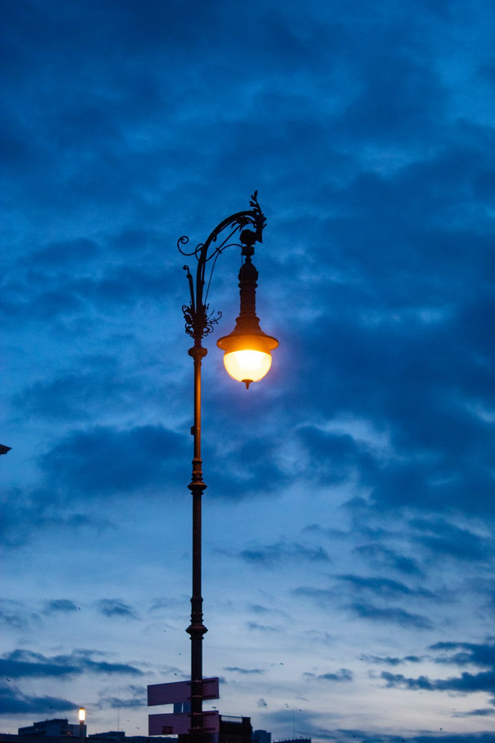 a street light on a cloudy night with a building in the background