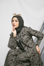 A stylish woman wearing modest fashion in a minimalist black and white setting with a subtle pop of color.