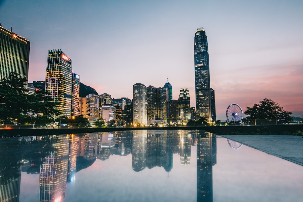 the skyline of a city is reflected in a pool