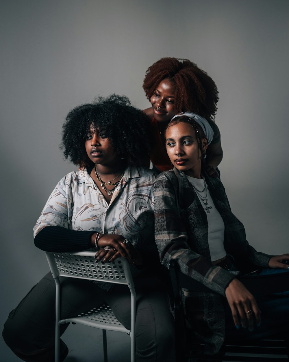 three women sitting on a chair posing for a picture