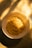 A bowl of cooked instant noodles is placed on a surface bathed in warm, golden sunlight. The light creates soft shadows and highlights on the noodles, enhancing their texture and inviting a sense of warmth.