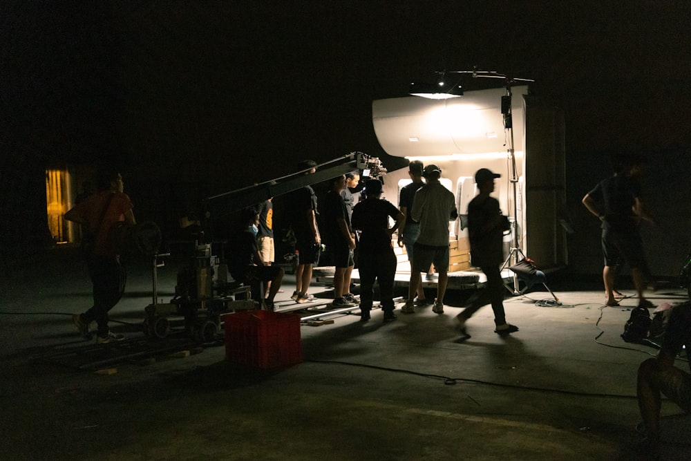 a group of people standing around a camera in the dark