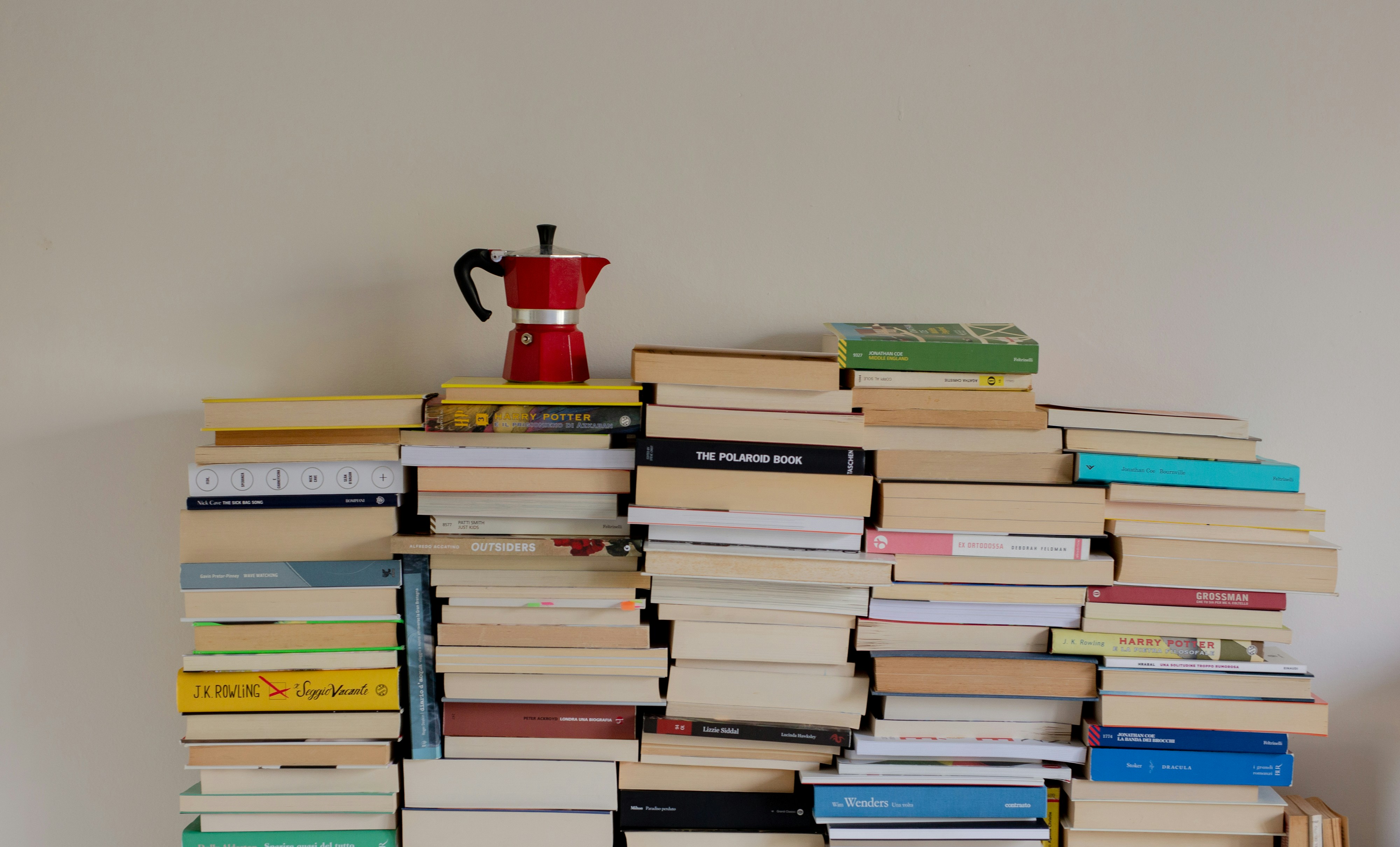 a stack of books sitting on top of a wooden shelf