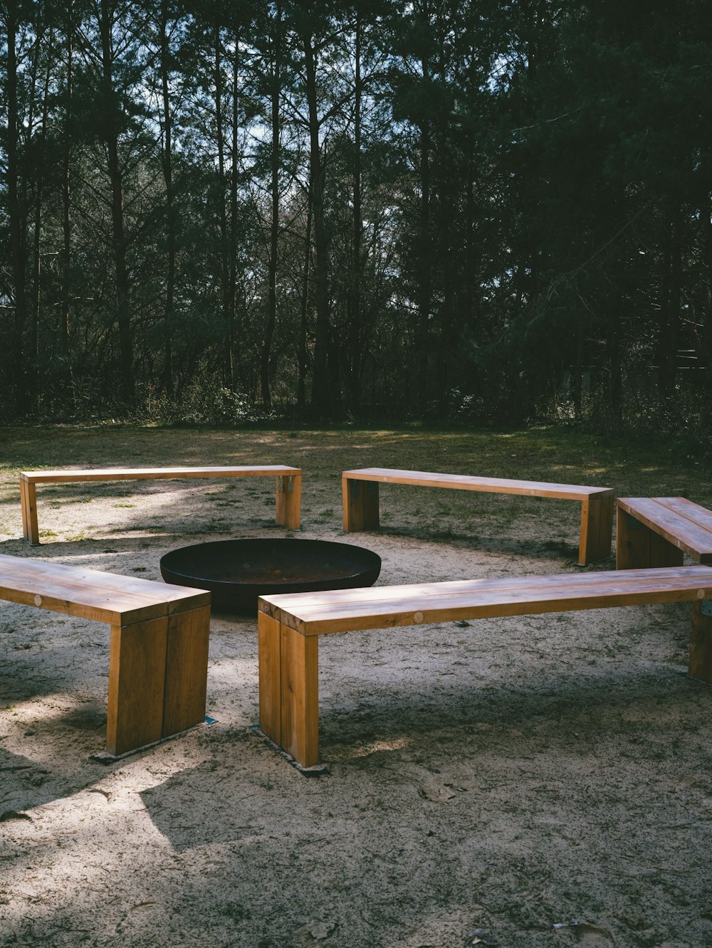 a group of wooden benches sitting next to a fire pit