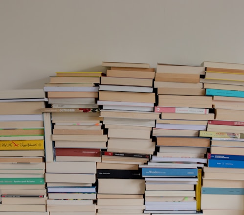a stack of books sitting on top of a wooden table