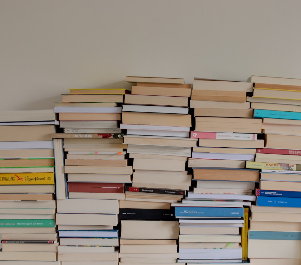 uma pilha de livros sentados em cima de uma mesa de madeira