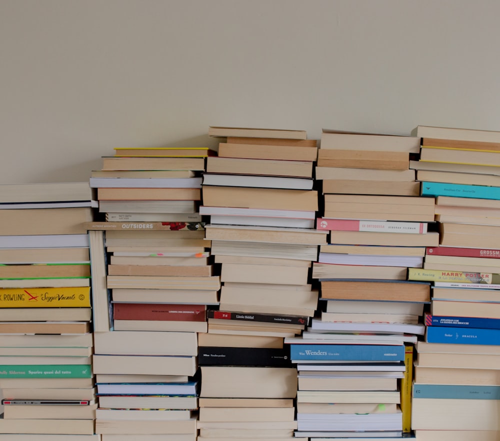 a stack of books sitting on top of a wooden table