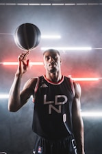 Close-up of a basketball spinning on a player's finger with the club's black and gold colors in the background.