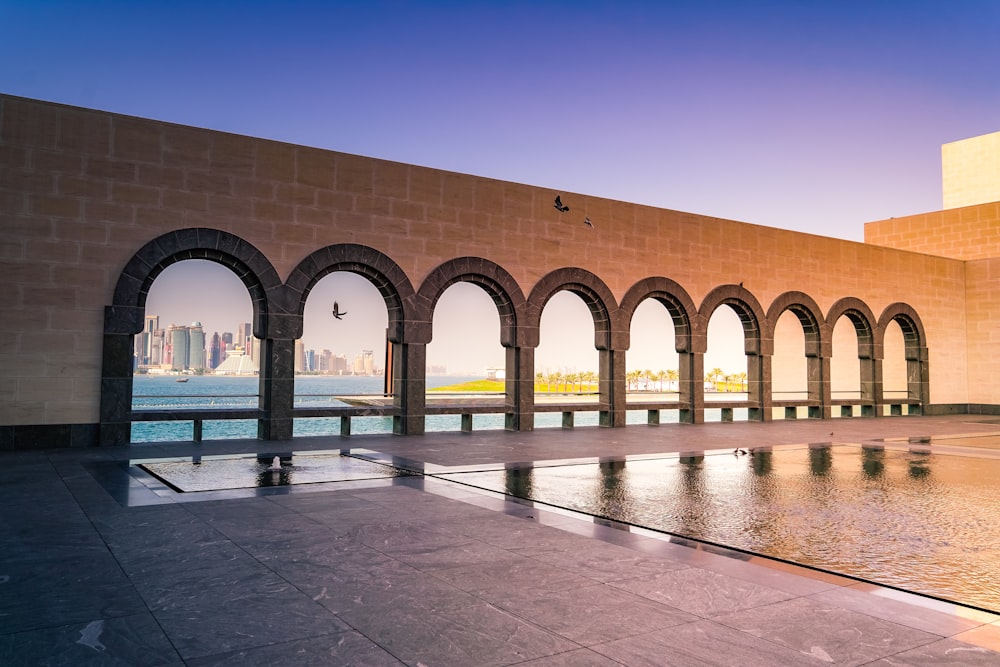 a building with arches and a pool in front of it