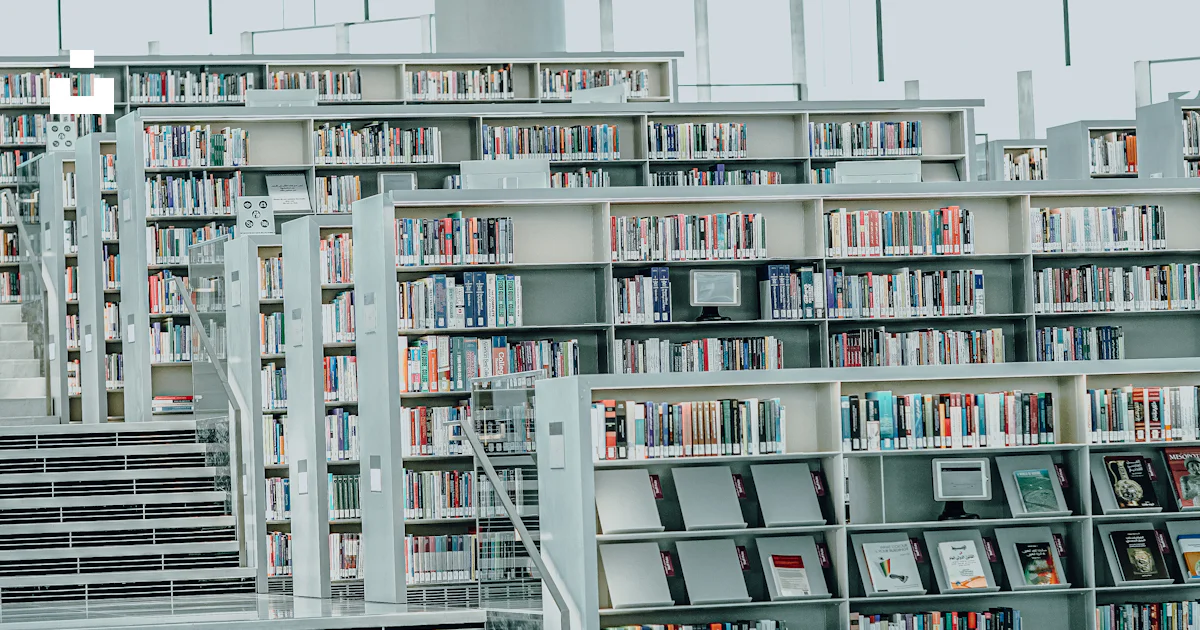 A library filled with lots of books and stairs photo – Free Books Image ...