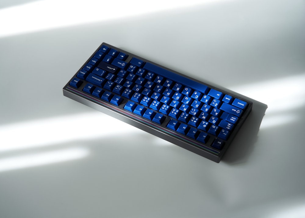 a blue keyboard sitting on top of a white table