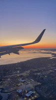 Aerial view of Dubai skyline at sunset from a plane window.