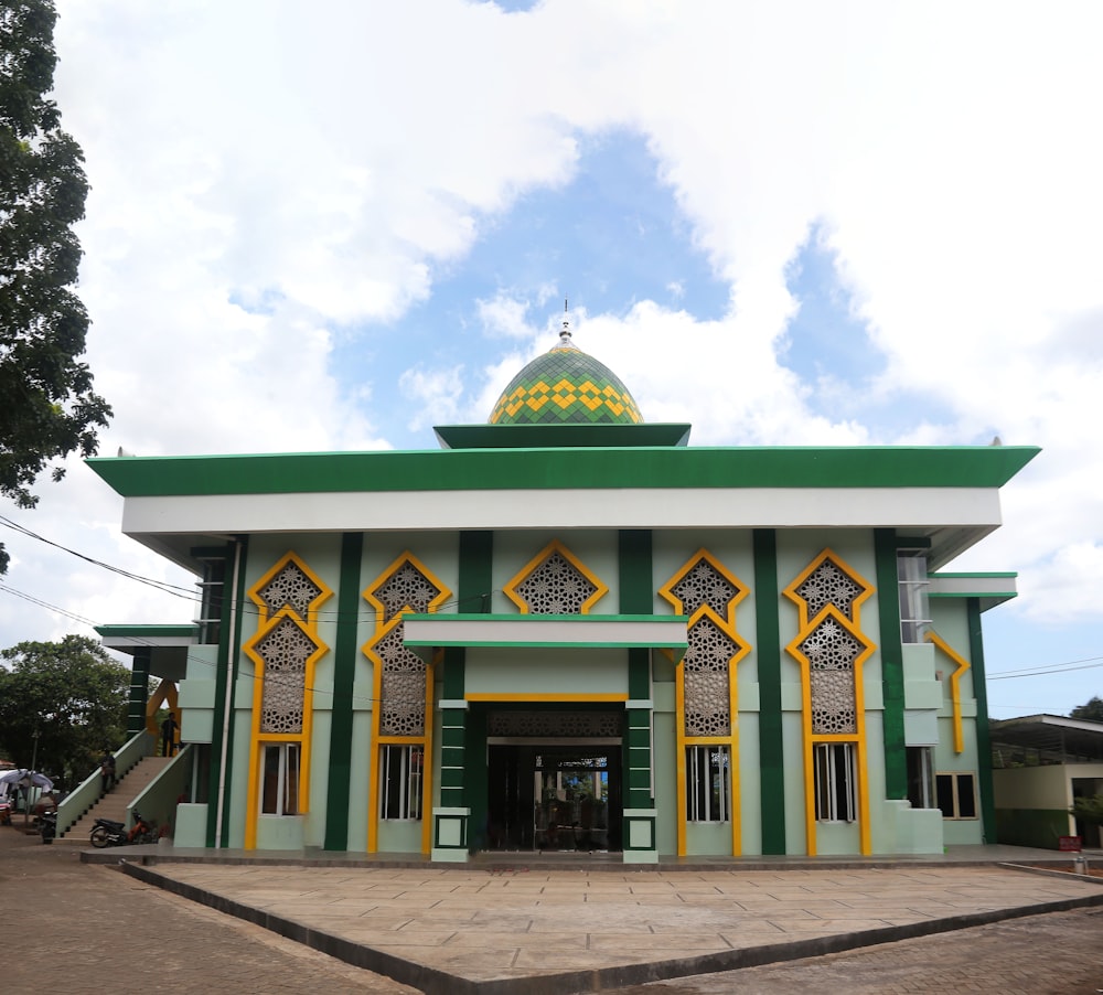 a green and yellow building with a green dome