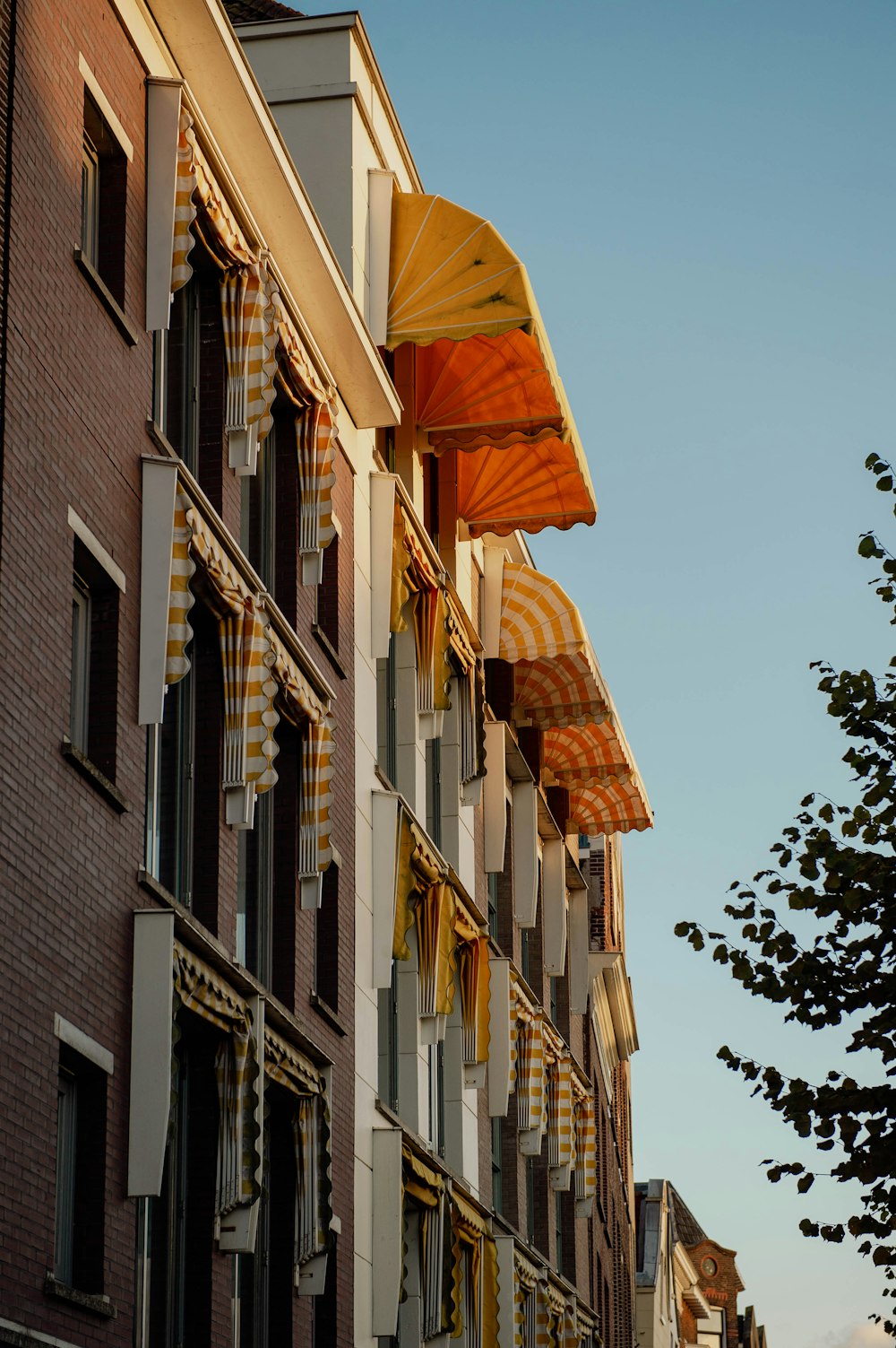 a row of buildings with open umbrellas hanging from them