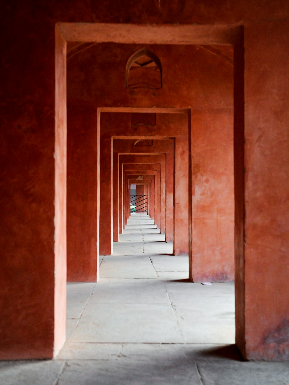 a long hallway lined with red walls and a clock