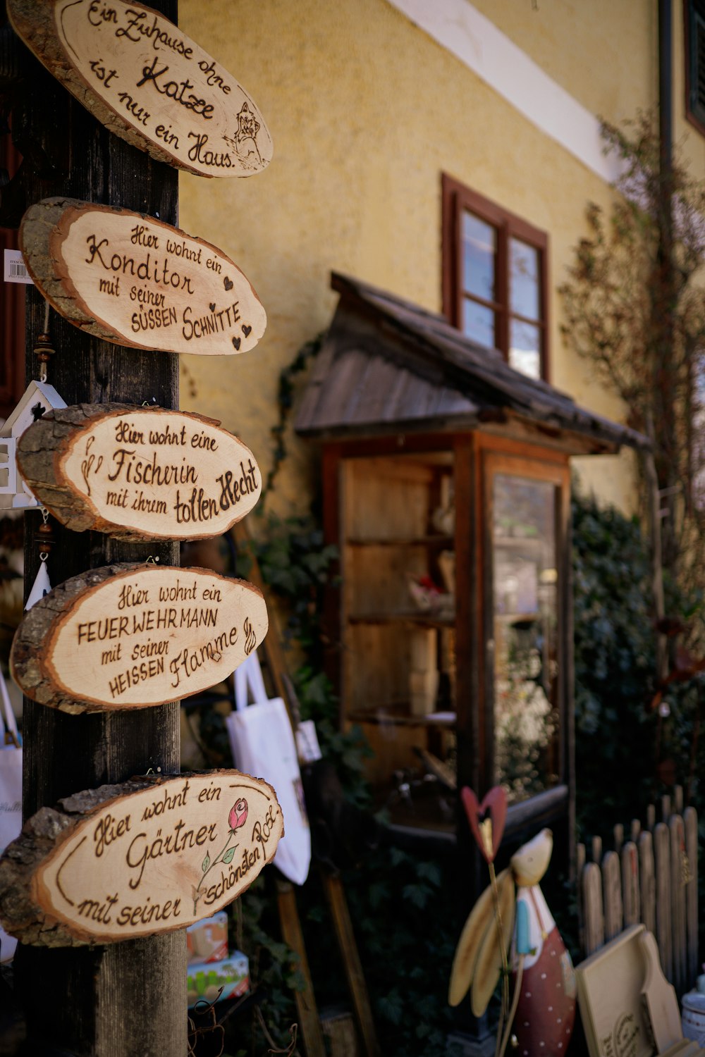 a wooden sign on a pole in front of a building