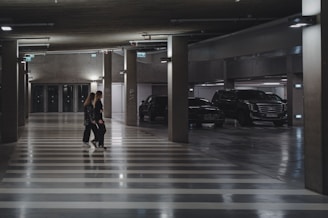 a couple of people that are walking in a parking garage