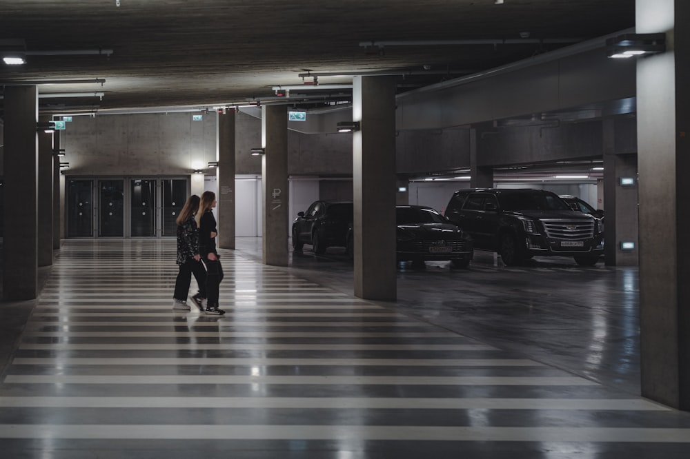 a couple of people that are walking in a parking garage