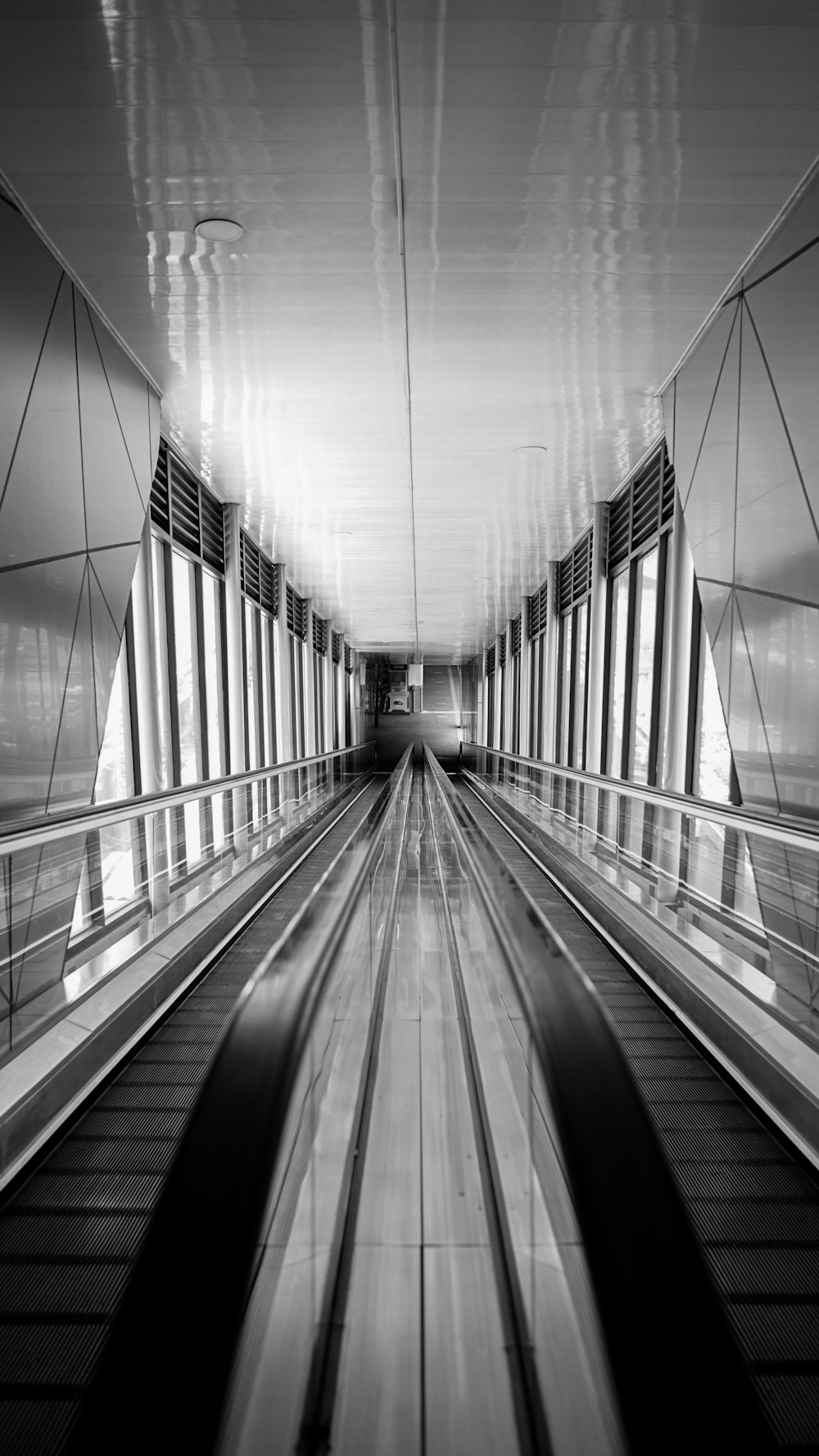 a black and white photo of an escalator