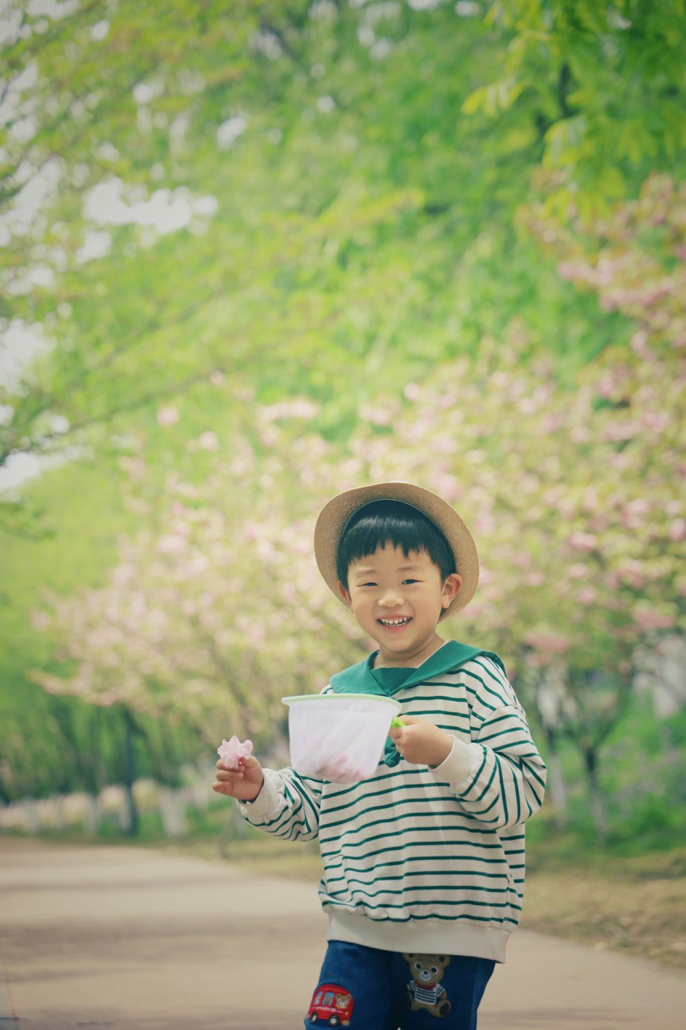 um menino em um chapéu segurando uma xícara de café